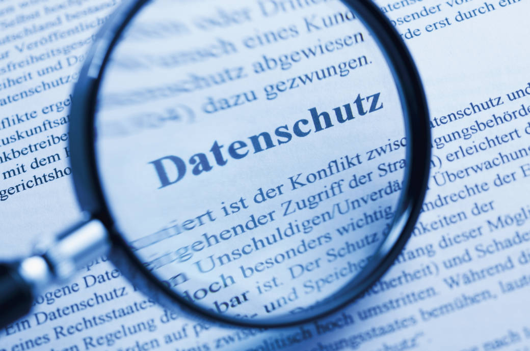 Magnifying glass over privacy policy, close up Datenschutz