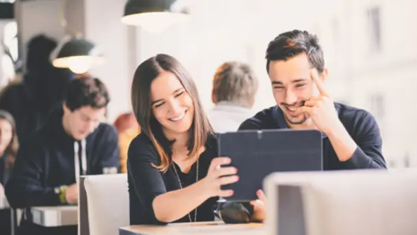 Fröhliche Menschen schauen ein Tablet an